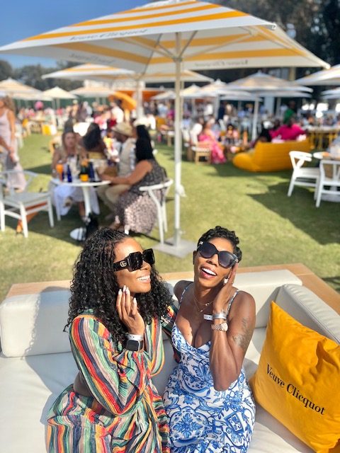 Two friends laughing together at a day party